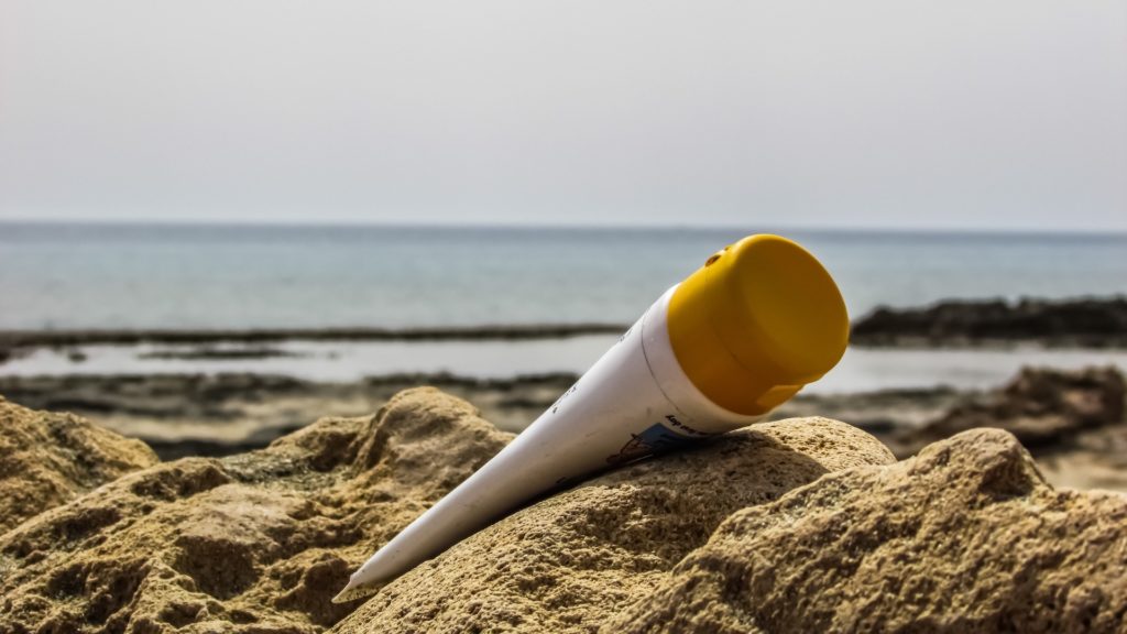 Une crème solaire posée dans le sable. // Source : Pxhere/CC0 Domaine public