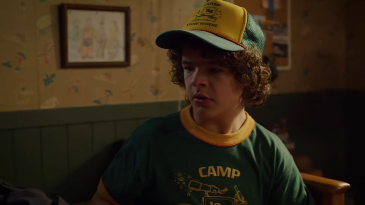 Dustin porte une casquette et un t Shirt « Camp Know Where » dans la saison 3. // Source : Youtube/Netflix