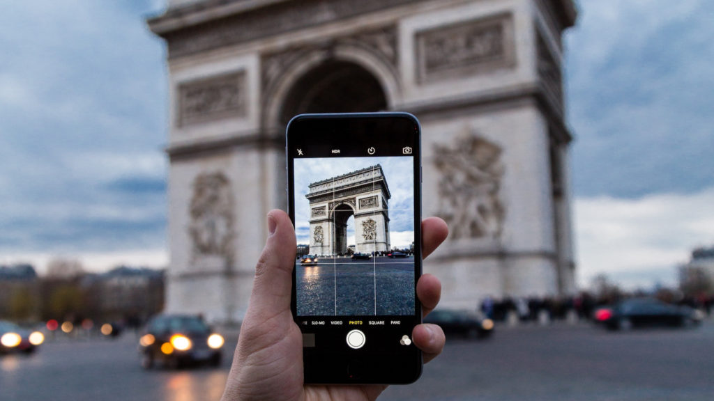 Une personne prend en photo l'Arc de Triomphe. // Source : Pxhere (photo recadrée)