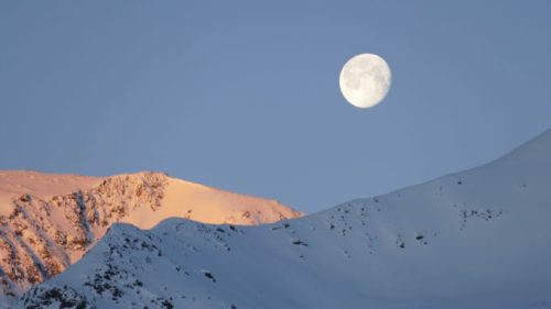 La Lune visible au dessus d'une montage enneigée. // Source : Pxfuel/CC0 (photo recadrée)