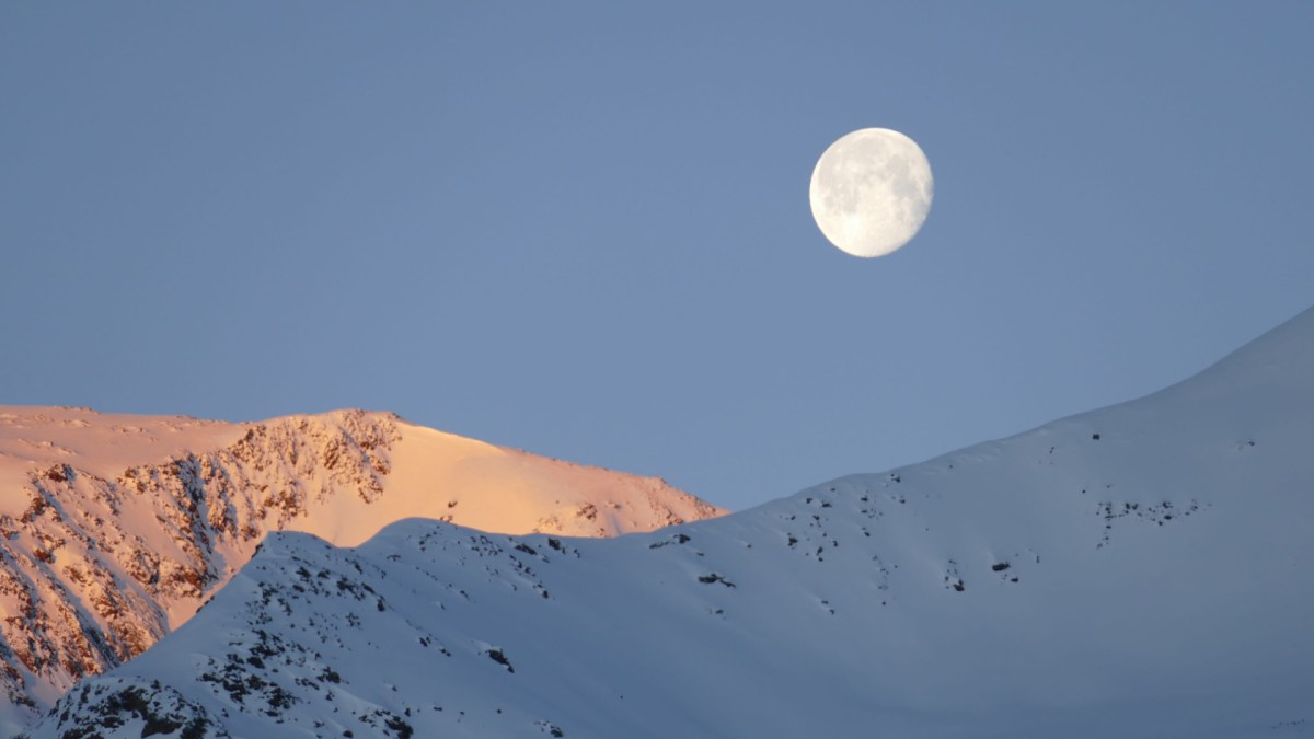 La Lune visible au dessus d'une montage enneigée. // Source : Pxfuel/CC0 (photo recadrée)