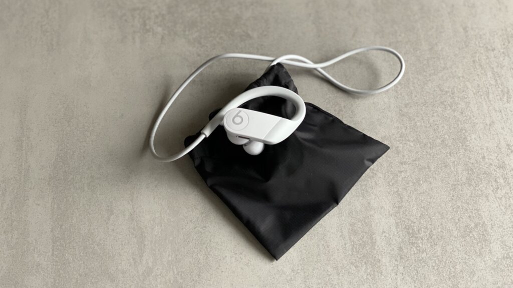 Les écouteurs Powerbeats et leur pochette de rangement // Source : Maxime Claudel pour Numerama Les écouteurs Powerbeats et leur pochette de rangement // Source : Maxime Claudel pour Numerama