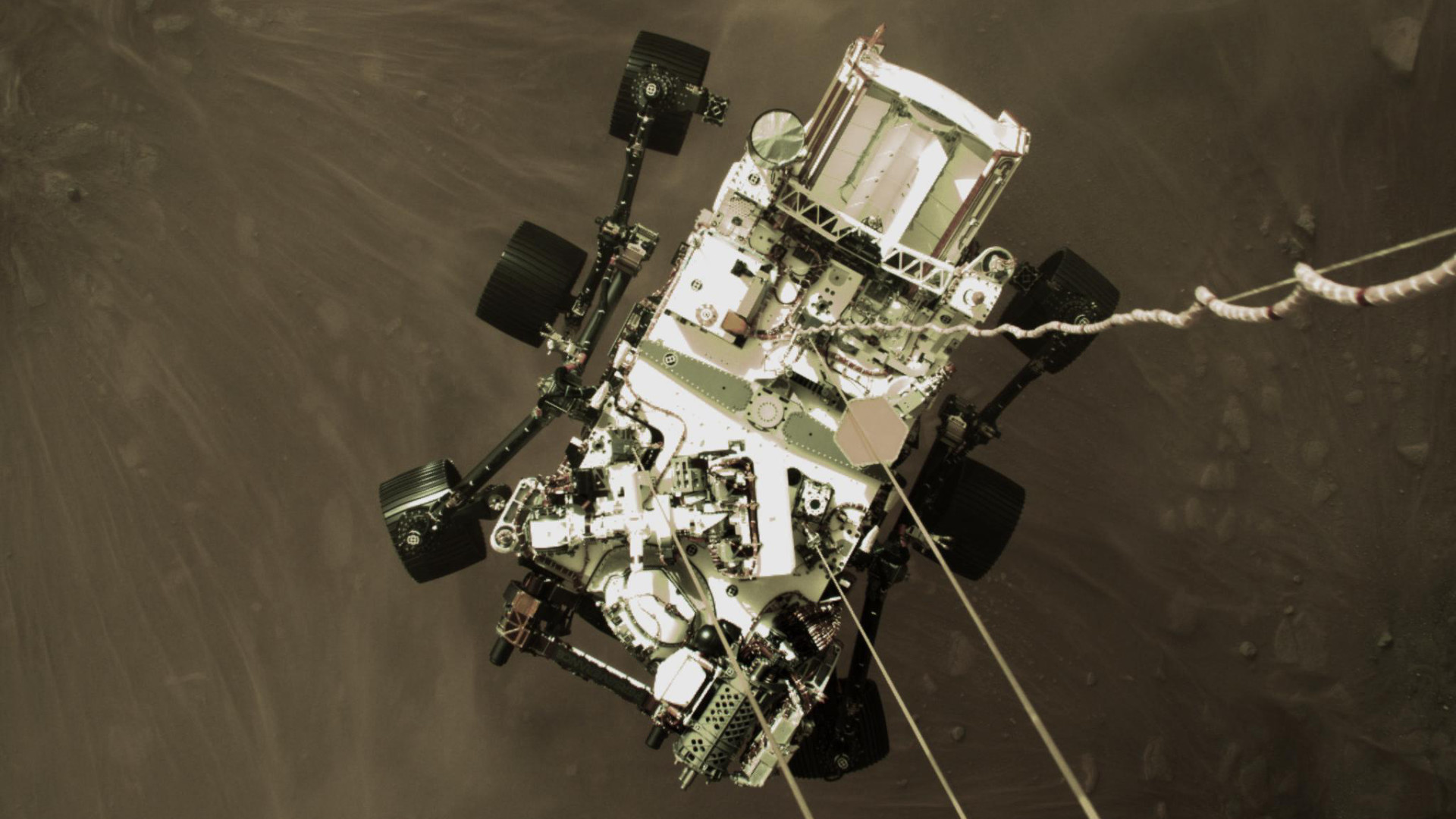 Perseverance suspendu par le « Sky Crane », au-dessus de la surface de Mars. // Source : NASA/JPL-Caltech (photo recadrée)
