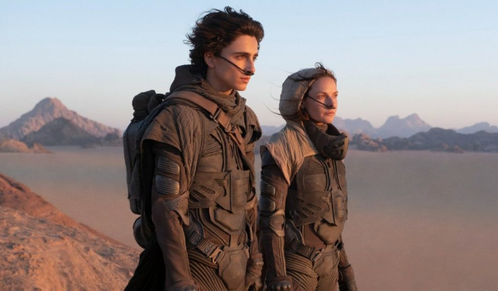 Paul et dame Jessica portant le distille dans le désert d'Arrakis. // Source : Warner Paul et dame Jessica portant le distille dans le désert d'Arrakis. // Source : Warner