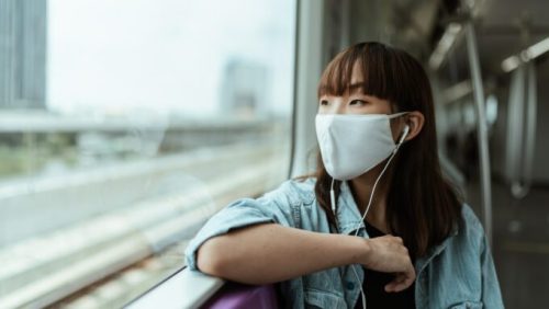 Une femme avec un masque dans un train // Source : Pexels