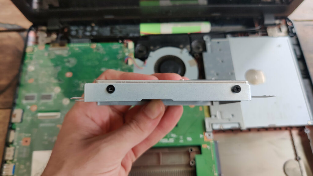 Enlevez les vis qui tiennent le disque dur à l'armature // Source : Photo Numerama Enlevez les vis qui tiennent le disque dur à l'armature // Source : Photo Numerama