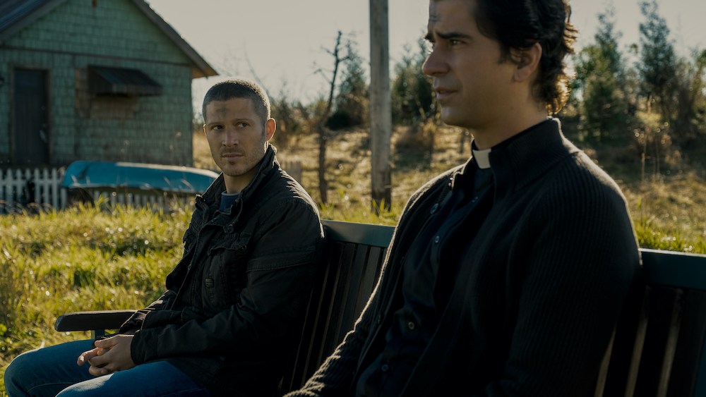 MIDNIGHT MASS (L to R) ZACH GILFORD as RILEY FLYNN and HAMISH LINKLATER as FATHER PAUL in episode 102 of MIDNIGHT MASS Cr. EIKE SCHROTER/NETFLIX © 2021