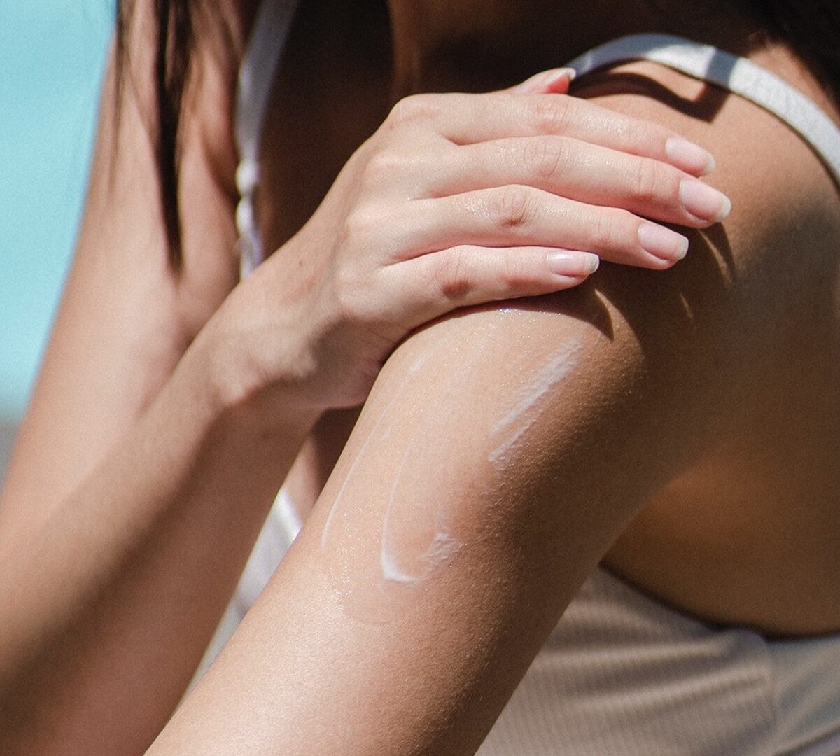 Personne au soleil appliquant de la crème solaire. // Source : Pexels