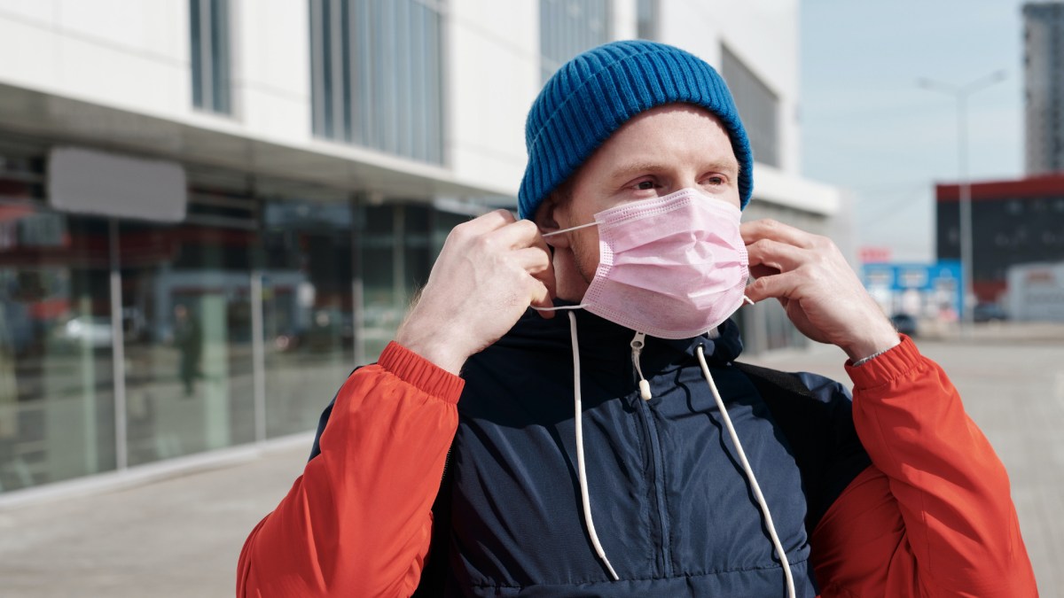 Une personne ôtant son masque. // Source : Pexels/Norma Mortenson (photo recadrée)