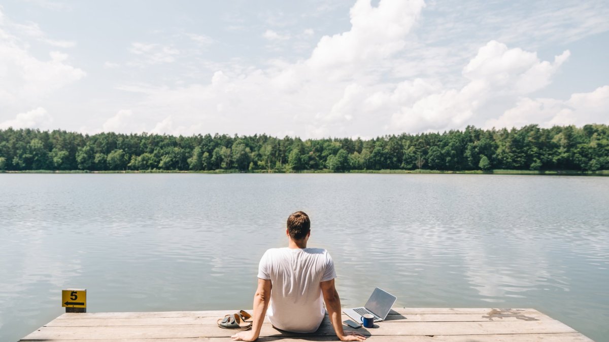 Un homme serein devant un lac parce que son smartphone et son PC sont protégés par un antivirus. // Source : iStock via Bitdefender