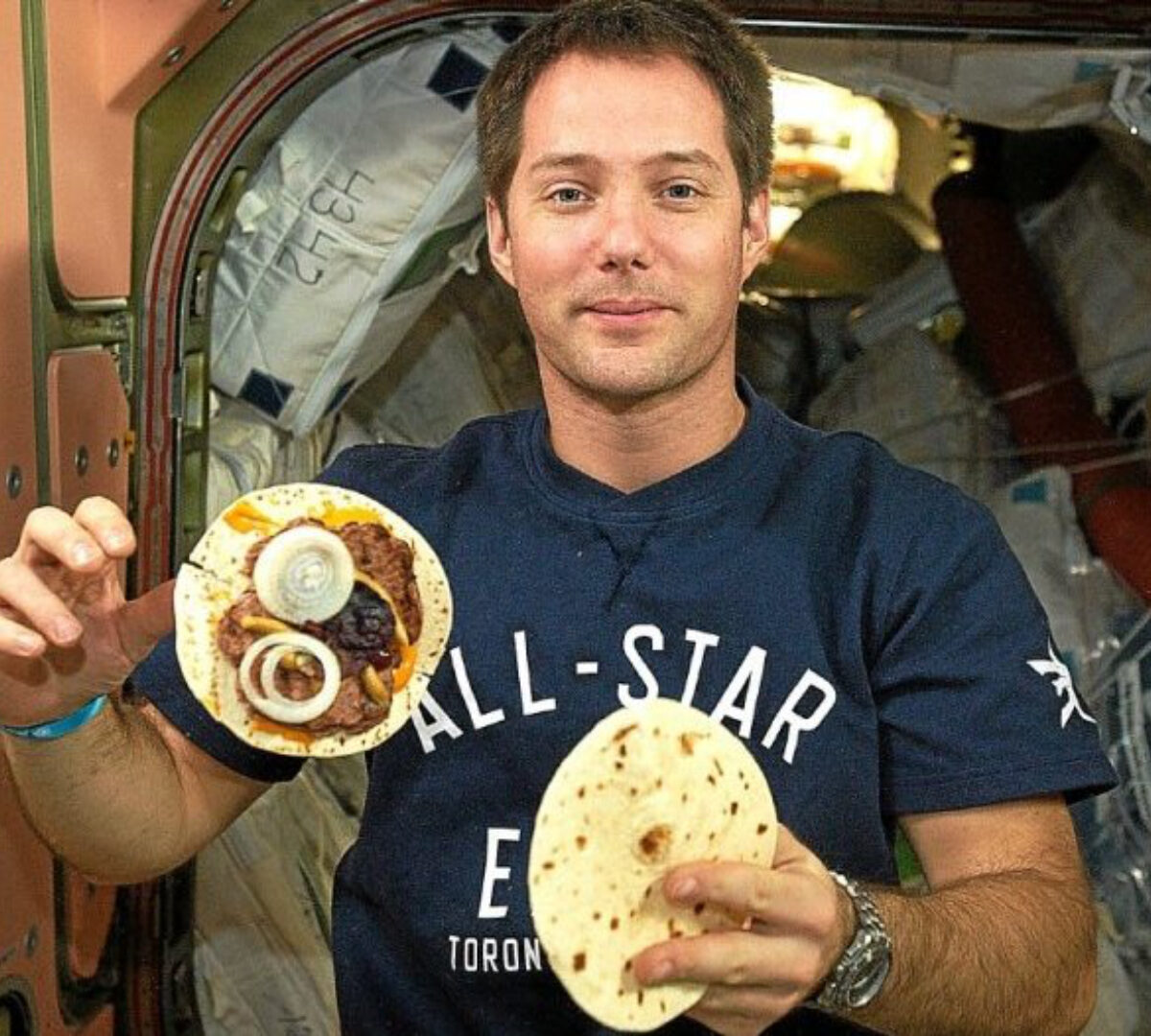 Repas pour Thomas Pesquet a bord de la station spatiale internationale. Burger maison : des tortillas, des galettes de boeuf rehydratees, les derniers oignons frais qu’il reste du ravitaillement de l’HTV-6, une feuille de laitue (cultivee dans la Station spatiale pour une experience scientifique) et des sauces diverses et variees. // Source : ESA