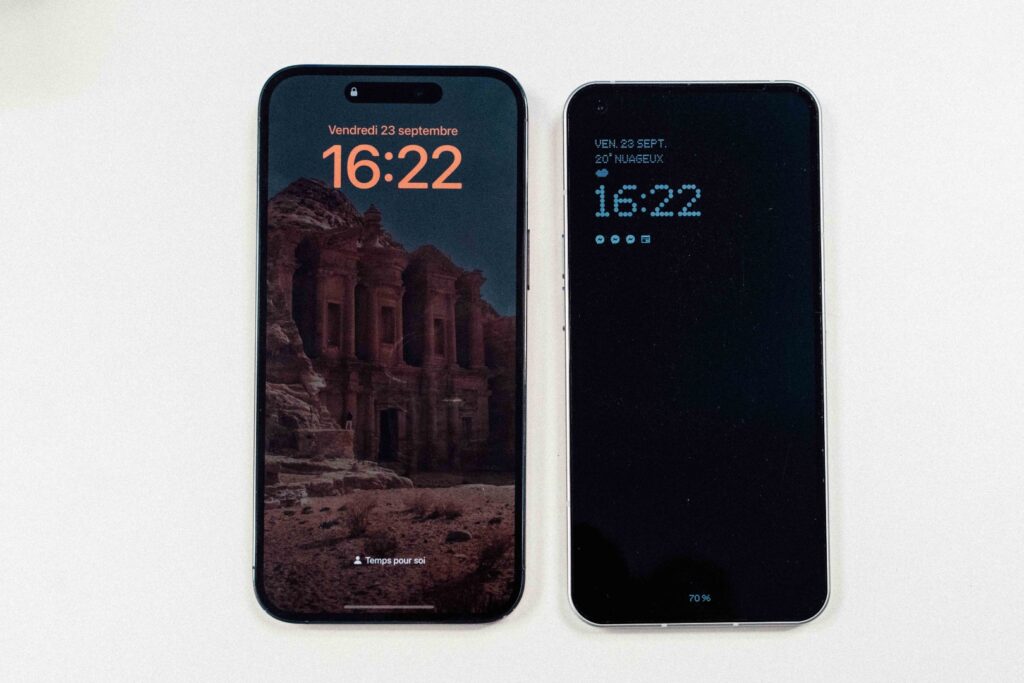 L'écran toujours allumé de l'iPhone 14 Pro Max à gauche, celui du Nothing Phone (1) à droite. Il est beaucoup plus discret et attire moins le regard. // Source : Anthony Wonner pour Numerama