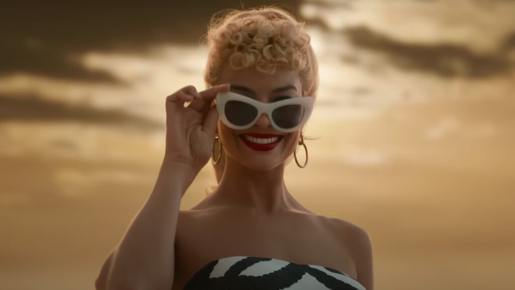 Margot Robbie se met dans la peau de la célèbre poupée Barbie.  // Source : Warner Bros sur Youtube. Capture d'écran Numerama.