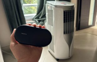 Le contrôle de clim connecté par Netatmo, à côté d'un climatiseur portable. // Source : Numerama