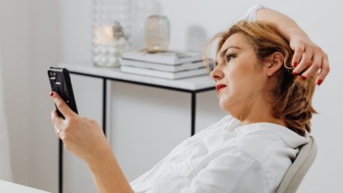 Une femme s'ennuie sur son smartphone // Source : Pexel