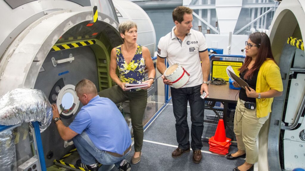 Entraînement en cas de dépressurisation dans la station. // Source : Wikimedia/CC/NASA/James Blair (photo recadrée)