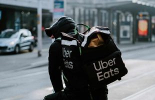 Un livreur Uber Eats  // Source : Claudio Schwarz / Unsplash
