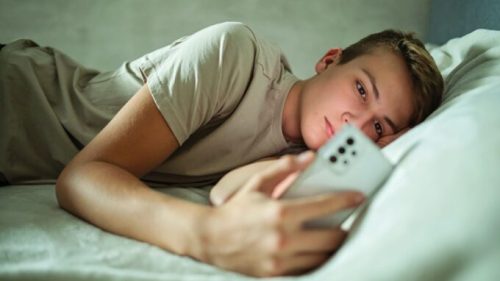 Un adolescent sur son smartphone. // Source : Canva