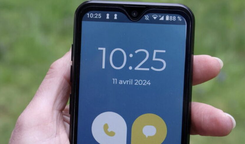 The phone shown to the Parisian looks like a Wiko device running Android with a simple application.
