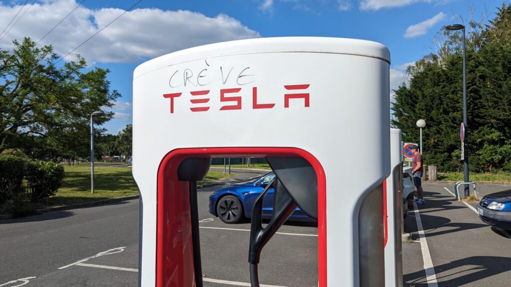 Un tag "crève Tesla" sur une borne de superchargeur HS // Source : Raphaelle Baut pour Numerama