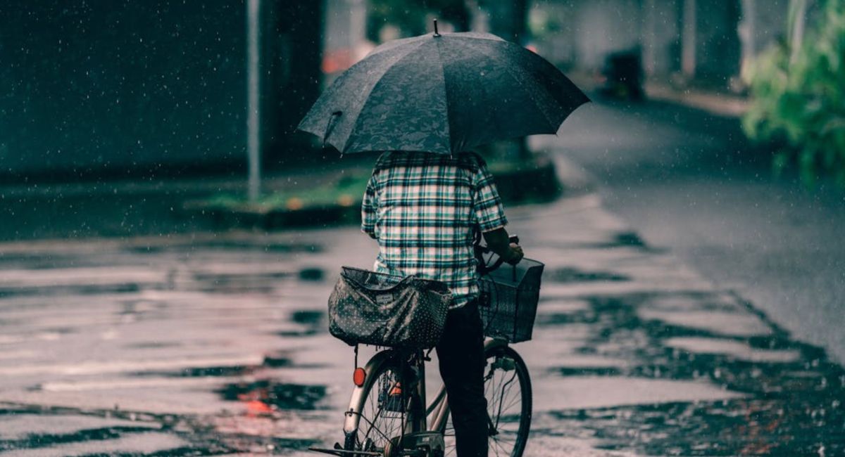 Personne à vélo sous un parapluie