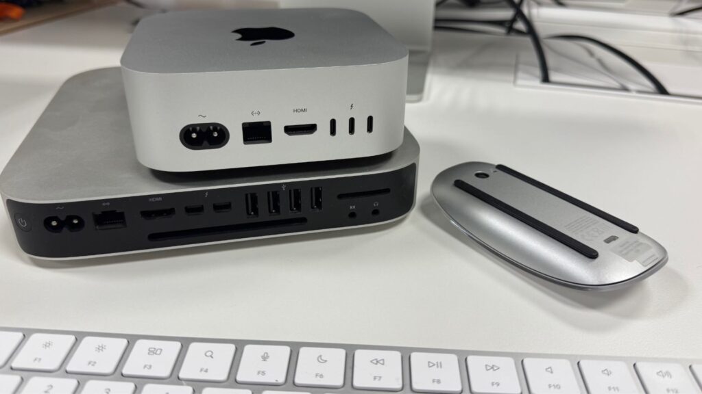 Les ports du Mac mini M4, en comparaison à une très ancienne génération de Mac mini. Apple n'a fait que des bons choix. (On en profite pour vous montrer la nouvelle Magic Mouse USB-C, qui n'a plus de logo Apple).