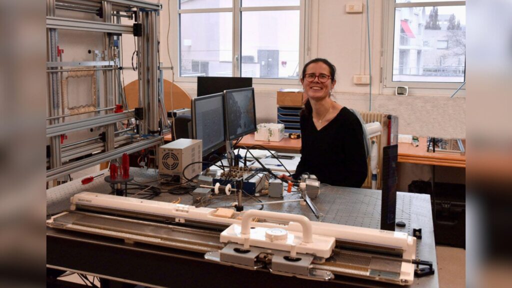 Audrey Steinberger près du dispositif expérimental : la machine de traction bi-axe est sur la droite. Au premier plan, la machine à tricoter qui permet de fabriquer les échantillons. // Source : CNRS, le Journal / Xavier Lassablière