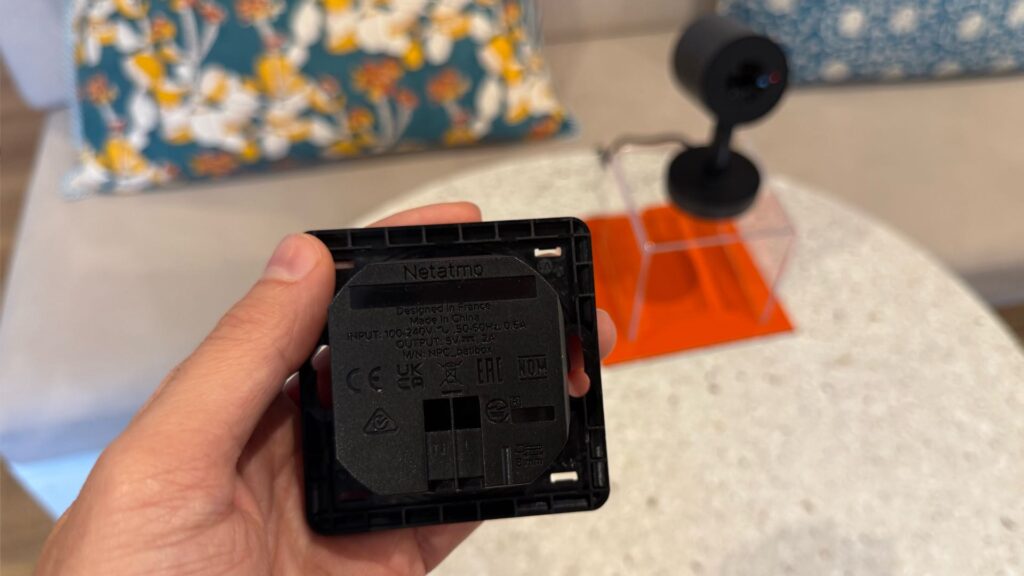 Ce support encastrable permet d'alimenter la caméra Netatmo sans fil visible. Un anneau en métal permet ensuite de cacher le support. // Source : Numerama