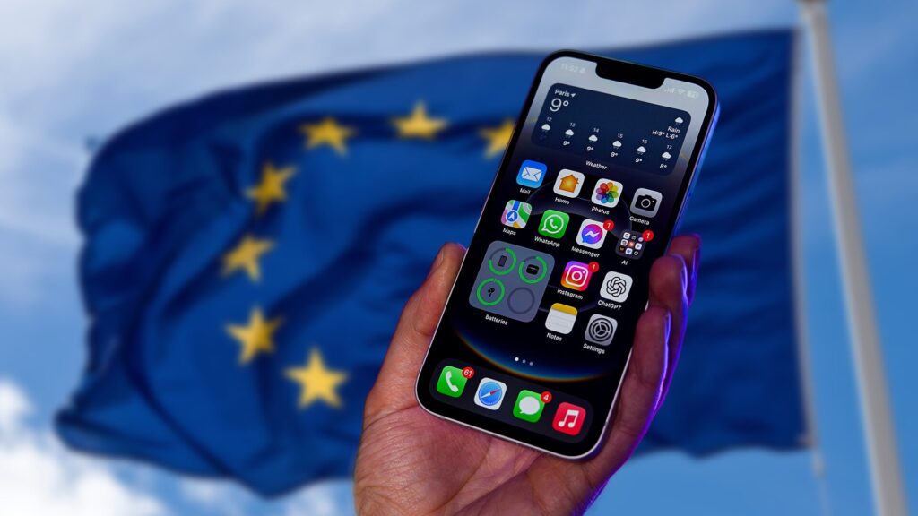 Un iPhone 16e devant un drapeau de l'Union européenne. // Source : Numerama Un iPhone 16e devant un drapeau de l'Union européenne. // Source : Numerama