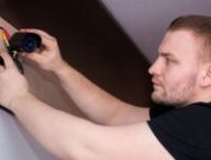 Un homme installe une caméra de surveillance // Source : Bermix Studio via Unsplash