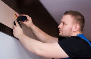 Un homme installe une caméra de surveillance // Source : Bermix Studio via Unsplash