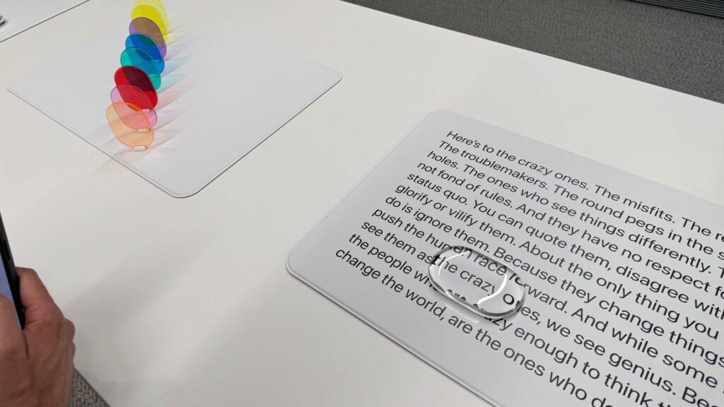 Une des nouveautés du Liquid Glass est un effet de zoom naturel dans une bulle de verre. Apple l'a testé avec une maquette physique. // Source : Numerama Une des nouveautés du Liquid Glass est un effet de zoom naturel dans une bulle de verre. Apple l'a testé avec une maquette physique. // Source : Numerama