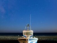 Bateau échoué sur une plage, sous un ciel étoilé. // Source : Canva