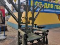 Le Trône de Fer en face de l'hôtel de ville de Kharkiv, en vrai matériel militaire, orné d'un trident ukrainien et d'une insulte envers Vladimir Poutine.