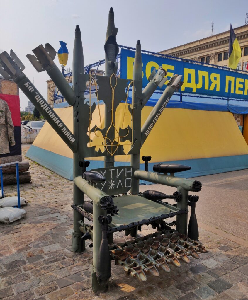 Le Trône de Fer en face de l'hôtel de ville de Kharkiv, en vrai matériel militaire, orné d'un trident ukrainien et d'une insulte envers Vladimir Poutine. Le Trône de Fer en face de l'hôtel de ville de Kharkiv, en vrai matériel militaire, orné d'un trident ukrainien et d'une insulte envers Vladimir Poutine.