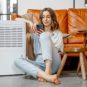 Une personne assise à côté d'un climatiseur. // Source : Envato