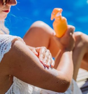 Personne en train d'appliquer de la crème solaire. // Source : Envato