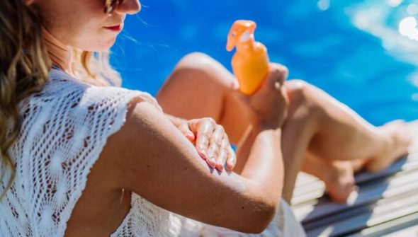 Personne en train d'appliquer de la crème solaire. // Source : Envato