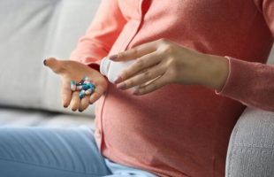 Femme enceinte prenant des médicaments. // Source : Canva