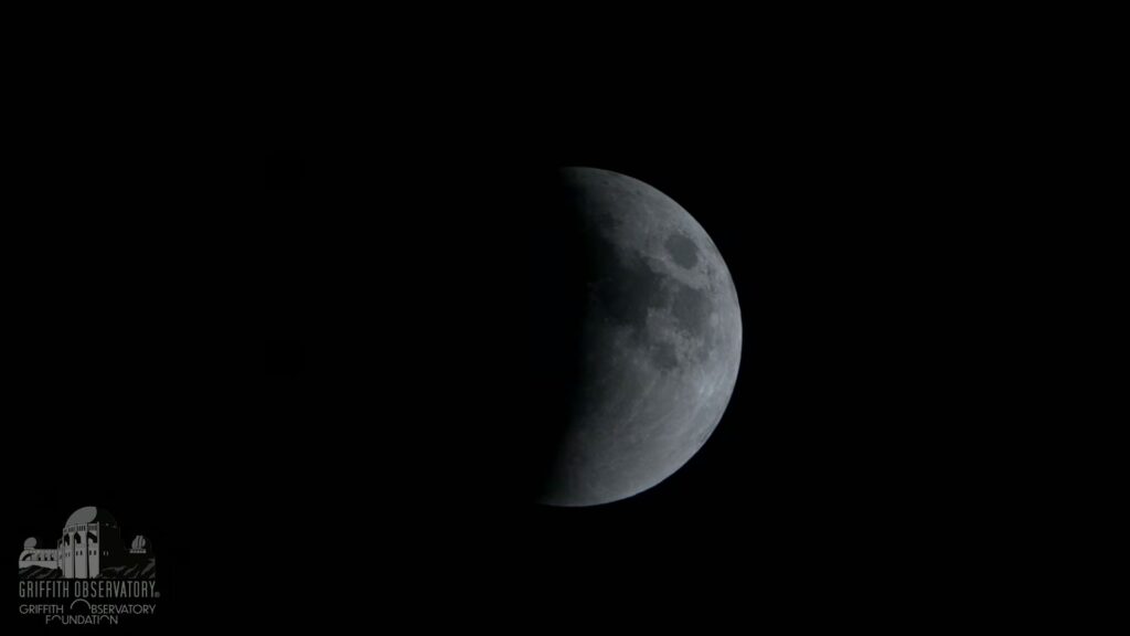 L'&eacute;clipse laisse d&eacute;sormais entrevoir une demi-Lune. // Source : Capture d'&eacute;cran YouTube Griffith Observatory