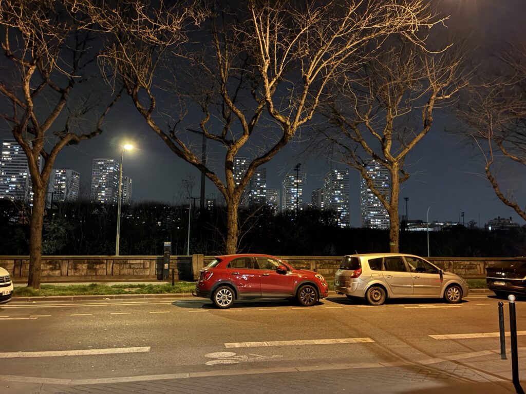 Photo de nuit prise avec l'iPhone 17e. De nombreux téléphones auraient du mal à gérer les lumières des immeubles, le téléphone d'Apple s'en sort bien.