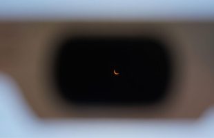 Observation d'une éclipse solaire à travers une paire de lunettes certifiée. // Source : Flickr/CC/drburtoni (image recadrée)