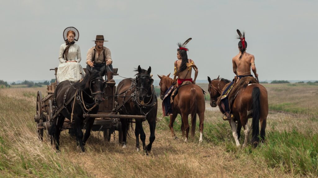 Little House on the Prairie. (L to R) Crosby Fitzgerald as Caroline Ingalls, Luke Bracey as Charles Ingalls, Corvin Mack as Myron, Xander Cole as Little Puma in episode 103 of Little House on the Prairie. Cr. Eric Zachanowich/Netflix © 2026 Little House on the Prairie. (L to R) Crosby Fitzgerald as Caroline Ingalls, Luke Bracey as Charles Ingalls, Corvin Mack as Myron, Xander Cole as Little Puma in episode 103 of Little House on the Prairie. Cr. Eric Zachanowich/Netflix © 2026