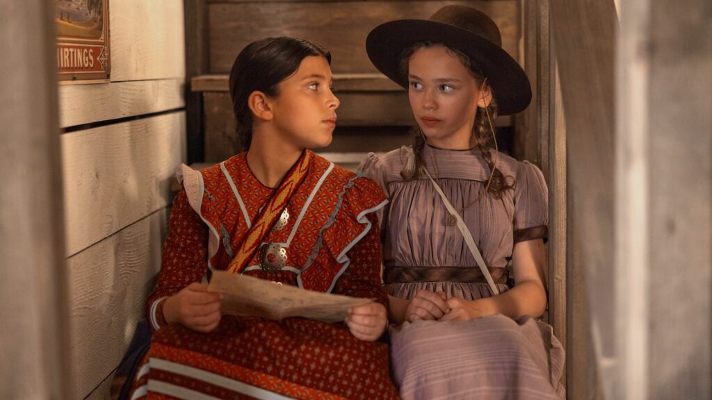Little House on the Prairie. (L to R) Wren Zhawenim Gotts as Good Eagle, Alice Halsey as Laura Ingalls in episode 107 of Little House on the Prairie. Cr. Eric Zachanowich/Netflix © 2026 Little House on the Prairie. (L to R) Wren Zhawenim Gotts as Good Eagle, Alice Halsey as Laura Ingalls in episode 107 of Little House on the Prairie. Cr. Eric Zachanowich/Netflix © 2026