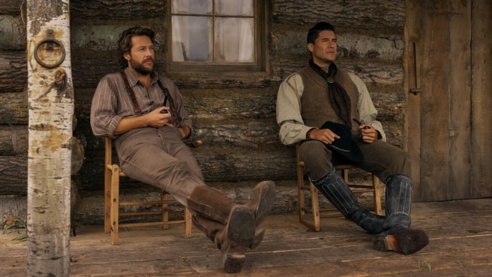 Little House on the Prairie. (L to R) Luke Bracey as Charles Ingalls, Meegwun Fairbrother as Mitchell in episode 108 of Little House on the Prairie. Cr. Eric Zachanowich/Netflix © 2026 Little House on the Prairie. (L to R) Luke Bracey as Charles Ingalls, Meegwun Fairbrother as Mitchell in episode 108 of Little House on the Prairie. Cr. Eric Zachanowich/Netflix © 2026